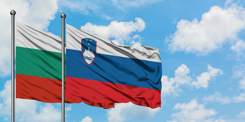 Bulgaria and Slovenia flag waving in the wind against white cloudy blue sky together. Diplomacy concept, international relations.