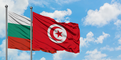 Bulgaria and Tunisia flag waving in the wind against white cloudy blue sky together. Diplomacy concept, international relations.