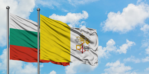 Bulgaria and Vatican City flag waving in the wind against white cloudy blue sky together. Diplomacy concept, international relations.