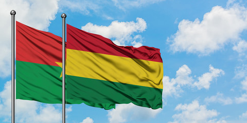 Burkina Faso and Bolivia flag waving in the wind against white cloudy blue sky together. Diplomacy concept, international relations.