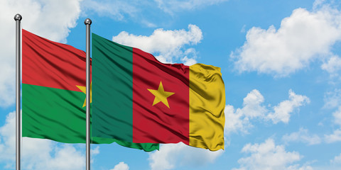 Burkina Faso and Cameroon flag waving in the wind against white cloudy blue sky together. Diplomacy concept, international relations.