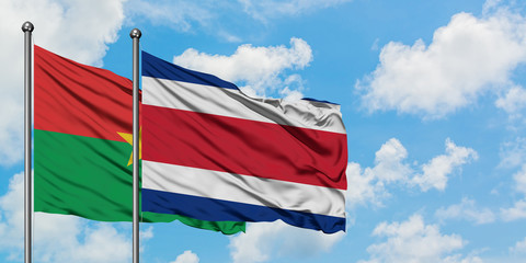 Burkina Faso and Costa Rica flag waving in the wind against white cloudy blue sky together. Diplomacy concept, international relations.