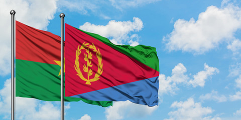 Burkina Faso and Eritrea flag waving in the wind against white cloudy blue sky together. Diplomacy concept, international relations.