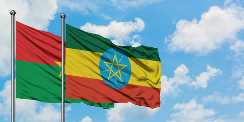Burkina Faso and Ethiopia flag waving in the wind against white cloudy blue sky together. Diplomacy concept, international relations.