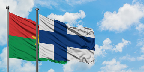 Burkina Faso and Finland flag waving in the wind against white cloudy blue sky together. Diplomacy concept, international relations.
