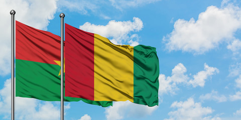 Burkina Faso and Guinea flag waving in the wind against white cloudy blue sky together. Diplomacy concept, international relations.