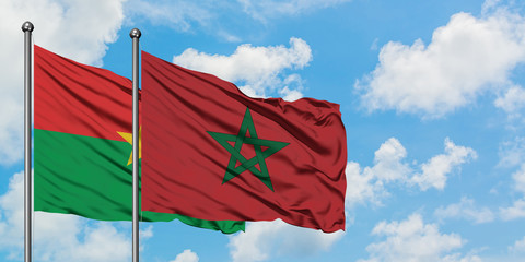 Burkina Faso and Morocco flag waving in the wind against white cloudy blue sky together. Diplomacy concept, international relations.