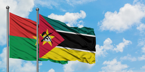 Burkina Faso and Mozambique flag waving in the wind against white cloudy blue sky together. Diplomacy concept, international relations.