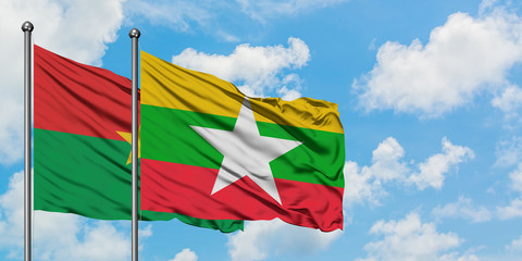 Burkina Faso and Myanmar flag waving in the wind against white cloudy blue sky together. Diplomacy concept, international relations.
