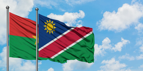 Burkina Faso and Namibia flag waving in the wind against white cloudy blue sky together. Diplomacy concept, international relations.