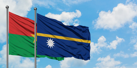 Burkina Faso and Nauru flag waving in the wind against white cloudy blue sky together. Diplomacy concept, international relations.