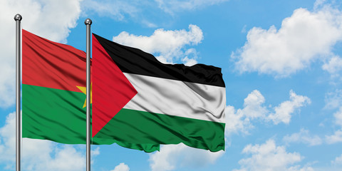 Burkina Faso and Palestine flag waving in the wind against white cloudy blue sky together. Diplomacy concept, international relations.