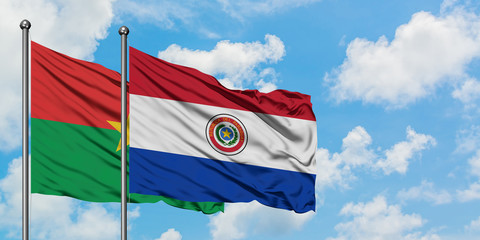 Burkina Faso and Paraguay flag waving in the wind against white cloudy blue sky together. Diplomacy concept, international relations.