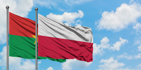 Burkina Faso and Poland flag waving in the wind against white cloudy blue sky together. Diplomacy concept, international relations.