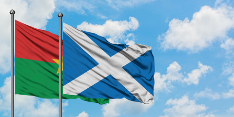 Burkina Faso and Scotland flag waving in the wind against white cloudy blue sky together. Diplomacy concept, international relations.
