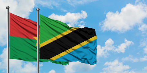 Burkina Faso and Tanzania flag waving in the wind against white cloudy blue sky together. Diplomacy concept, international relations.
