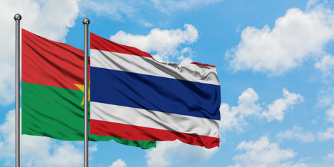 Burkina Faso and Thailand flag waving in the wind against white cloudy blue sky together. Diplomacy concept, international relations.