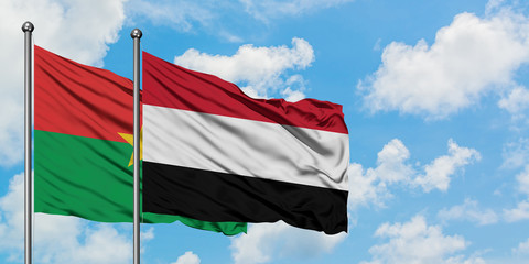 Burkina Faso and Yemen flag waving in the wind against white cloudy blue sky together. Diplomacy concept, international relations.