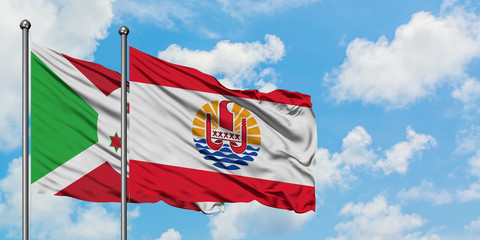 Burundi and French Polynesia flag waving in the wind against white cloudy blue sky together. Diplomacy concept, international relations.