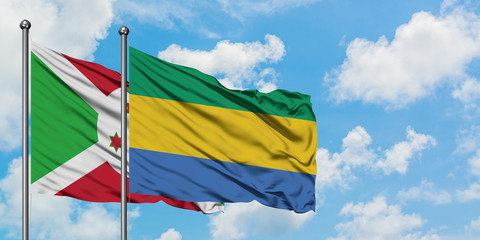 Burundi and Gabon flag waving in the wind against white cloudy blue sky together. Diplomacy concept, international relations.