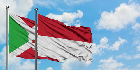 Burundi and Indonesia flag waving in the wind against white cloudy blue sky together. Diplomacy concept, international relations.