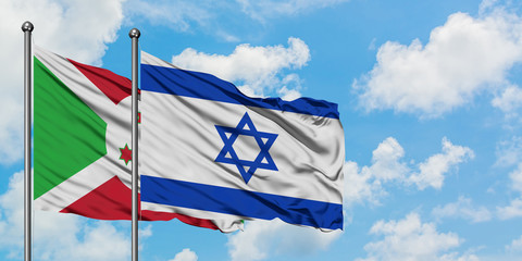 Burundi and Israel flag waving in the wind against white cloudy blue sky together. Diplomacy concept, international relations.