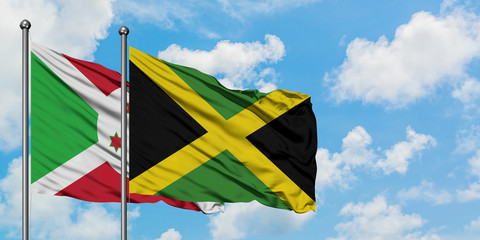Burundi and Jamaica flag waving in the wind against white cloudy blue sky together. Diplomacy concept, international relations.