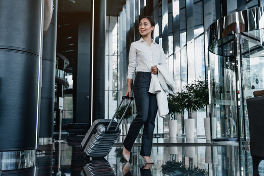 Asian female business traveler walking in airport hallway