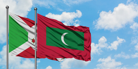 Burundi and Maldives flag waving in the wind against white cloudy blue sky together. Diplomacy concept, international relations.
