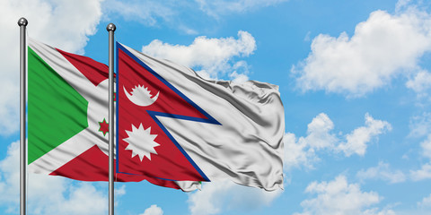 Burundi and Nepal flag waving in the wind against white cloudy blue sky together. Diplomacy concept, international relations.