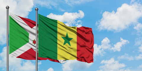 Burundi and Senegal flag waving in the wind against white cloudy blue sky together. Diplomacy concept, international relations.