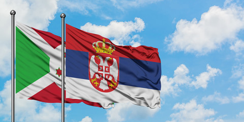 Burundi and Serbia flag waving in the wind against white cloudy blue sky together. Diplomacy concept, international relations.
