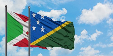 Burundi and Solomon Islands flag waving in the wind against white cloudy blue sky together. Diplomacy concept, international relations.