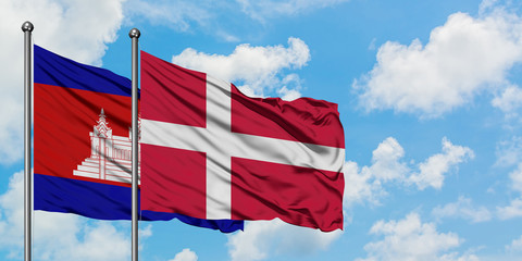 Cambodia and Denmark flag waving in the wind against white cloudy blue sky together. Diplomacy concept, international relations.