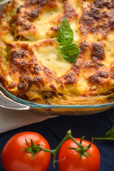 Tasty lasagna, italian cuisine. Pasta. Vertical frame with ingredients. On blue wooden background