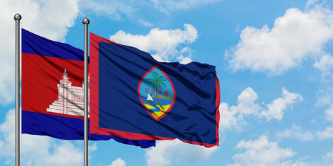 Cambodia and Guam flag waving in the wind against white cloudy blue sky together. Diplomacy concept, international relations.