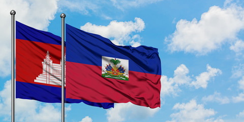 Cambodia and Haiti flag waving in the wind against white cloudy blue sky together. Diplomacy concept, international relations.