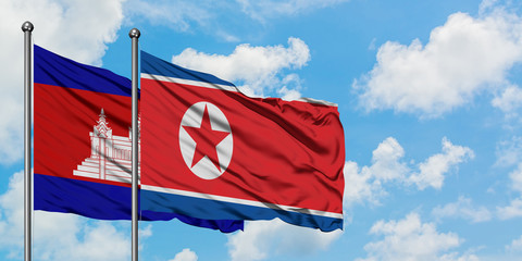 Cambodia and North Korea flag waving in the wind against white cloudy blue sky together. Diplomacy concept, international relations.