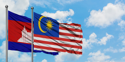 Cambodia and Malaysia flag waving in the wind against white cloudy blue sky together. Diplomacy concept, international relations.