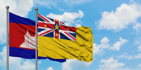 Cambodia and Niue flag waving in the wind against white cloudy blue sky together. Diplomacy concept, international relations.