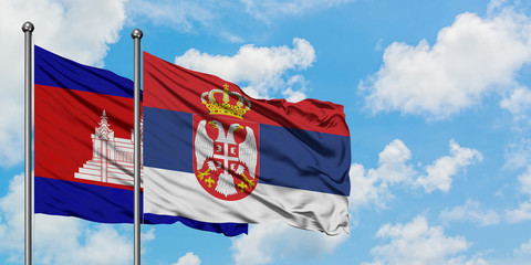 Cambodia and Serbia flag waving in the wind against white cloudy blue sky together. Diplomacy concept, international relations.