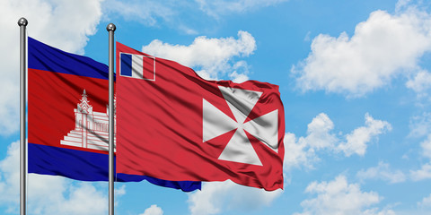 Cambodia and Wallis And Futuna flag waving in the wind against white cloudy blue sky together....