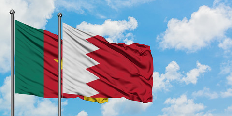 Cameroon and Bahrain flag waving in the wind against white cloudy blue sky together. Diplomacy concept, international relations.