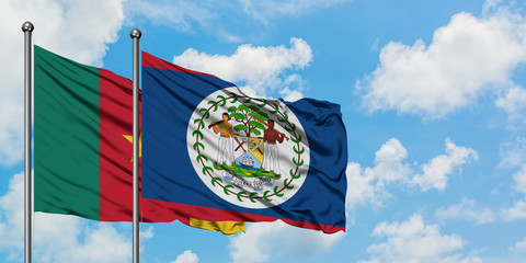 Cameroon and Belize flag waving in the wind against white cloudy blue sky together. Diplomacy concept, international relations.