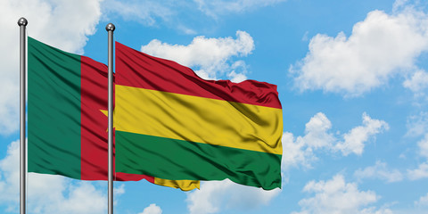 Cameroon and Bolivia flag waving in the wind against white cloudy blue sky together. Diplomacy concept, international relations.