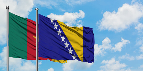 Cameroon and Bosnia Herzegovina flag waving in the wind against white cloudy blue sky together. Diplomacy concept, international relations.
