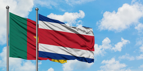 Cameroon and Costa Rica flag waving in the wind against white cloudy blue sky together. Diplomacy concept, international relations.