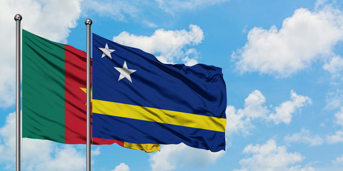 Cameroon and Curacao flag waving in the wind against white cloudy blue sky together. Diplomacy concept, international relations.