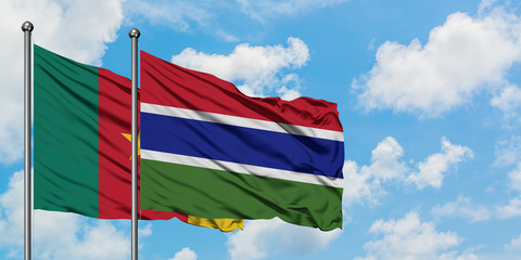 Cameroon and Gambia flag waving in the wind against white cloudy blue sky together. Diplomacy concept, international relations.