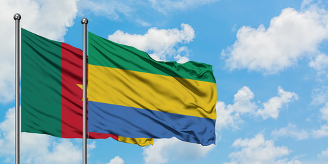 Cameroon and Gabon flag waving in the wind against white cloudy blue sky together. Diplomacy...
